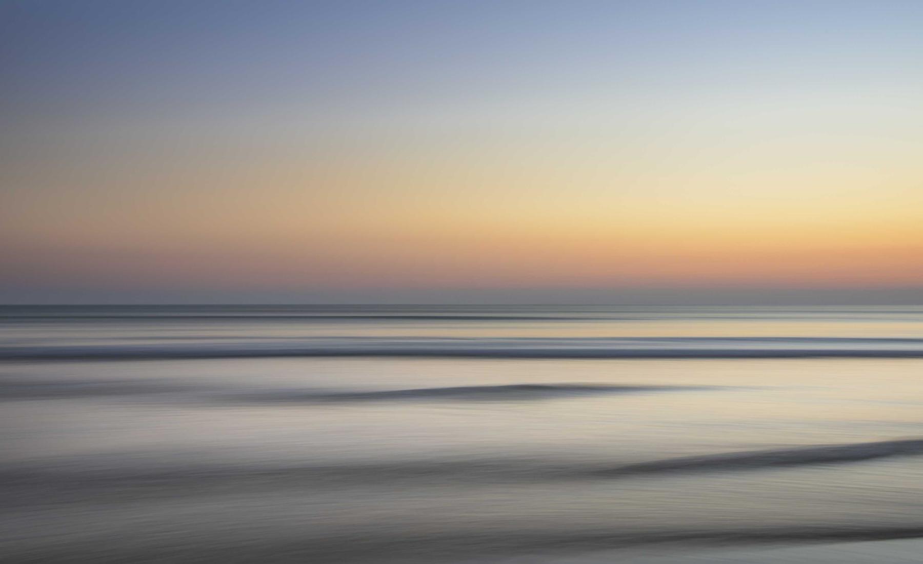 Long-exposure sea surface at dusk, banded horizon