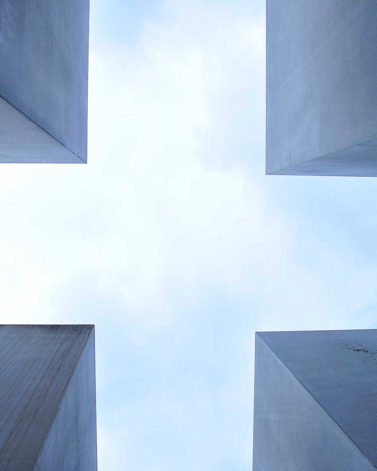 Looking up between concrete towers at the sky